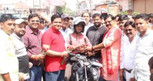 हेलमेट लगाकर दोपहिया चलाने वाले वाहन चालकों को पुष्प भेंट
